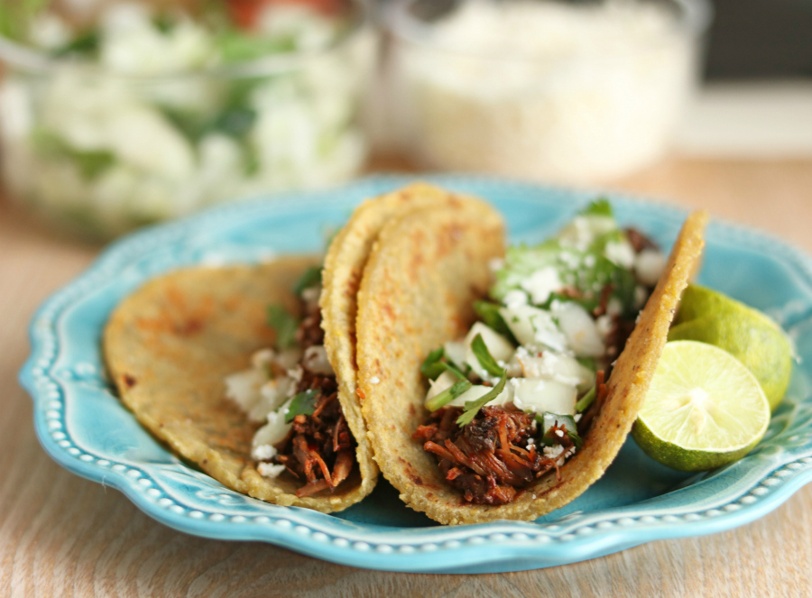 Instant Pot Beef Barbacoa - served on tortillas on a blue plate