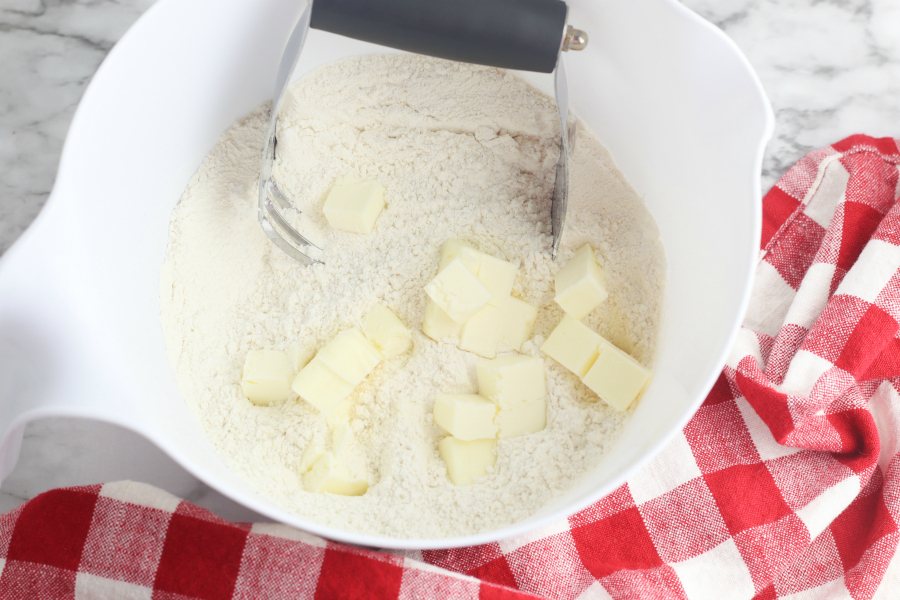 flour, baking powder, sugar, salt, and garlic powder and cubed butter in a mixing bowl with a pastry cutter.