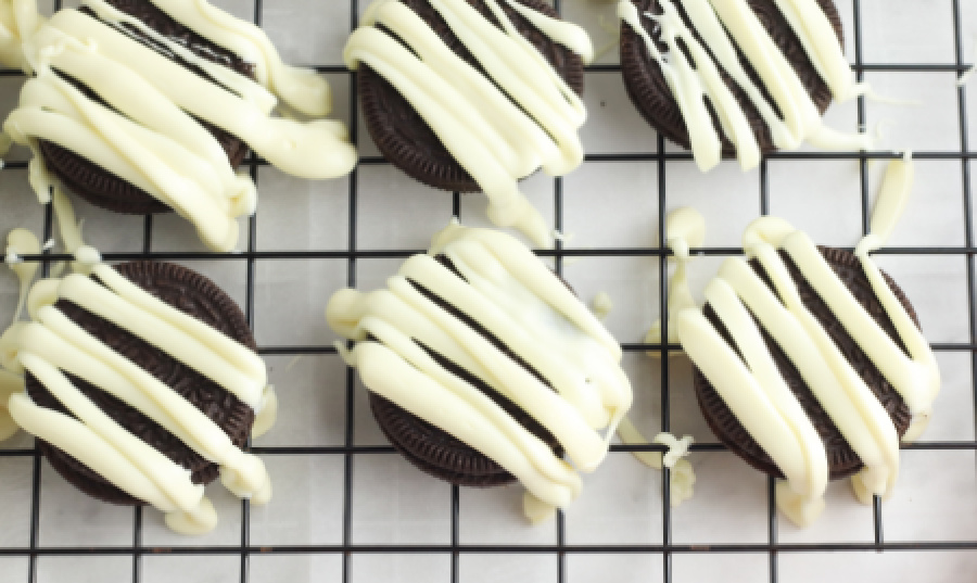  Oreo Cookies on drying rack with streaks of white chocolate