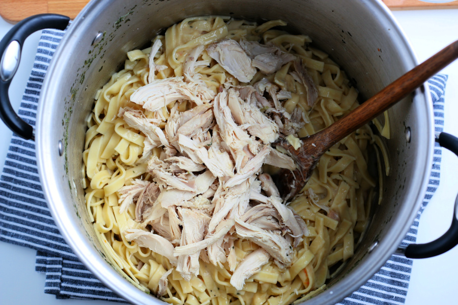 noodle mixture and chicken pieces in a large pot