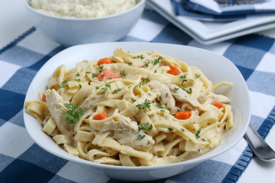chicken and noodles in a white serving bowl