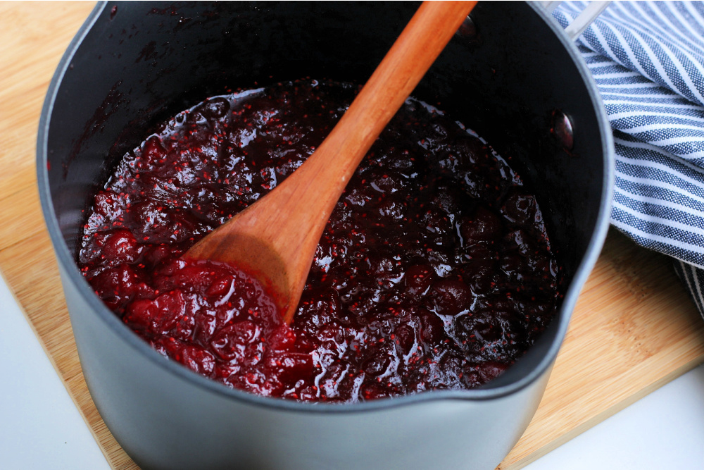 cranberry sauce in a pan with wooden spoon
