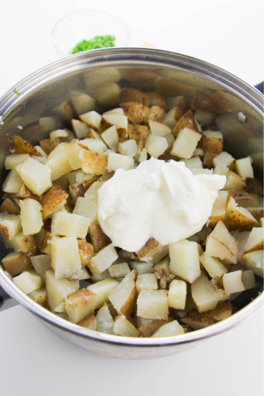 adding sour cream, milk and butter to the potatoes