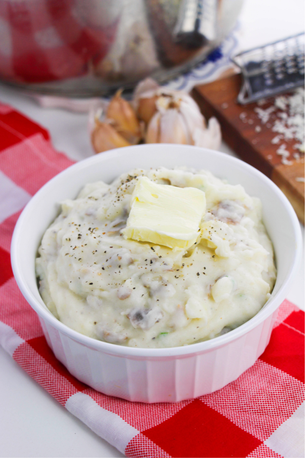 garlic mashed potatoes in a white bowl with a tab of butter
