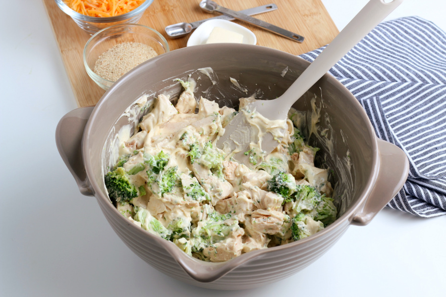 adding chicken and broccoli to mixing bowl with soup mixture