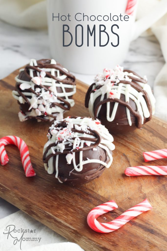 3 hot chocolate bombs on a cutting board with mini candy canes