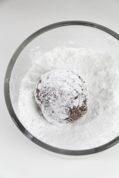 rolling dough ball in powdered sugar