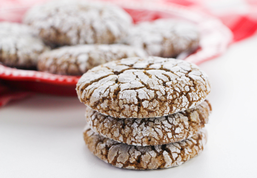 Gingerbread Crinkle Cookies stacked on a red plate and stacked next to the plate