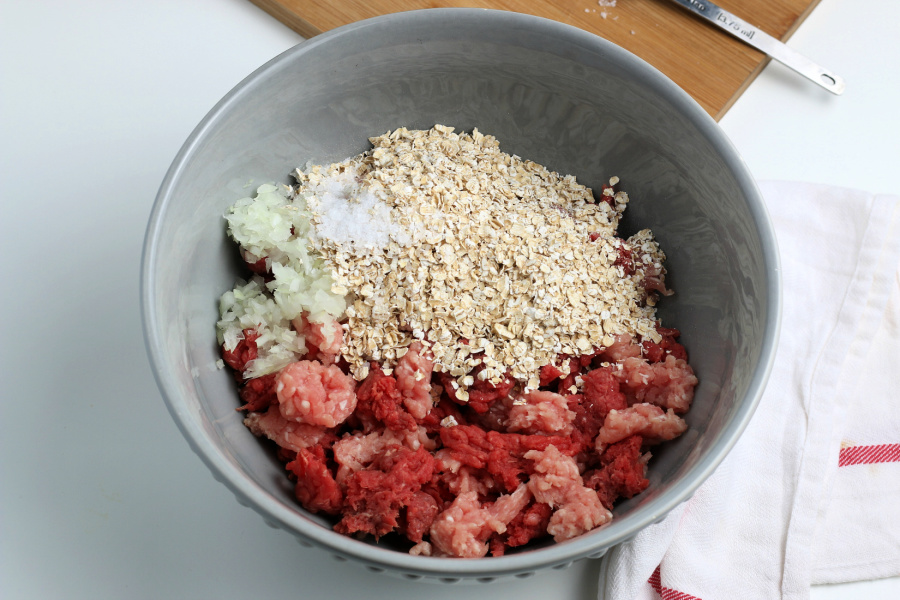 ingredients for meatballs in a mixing bowl
