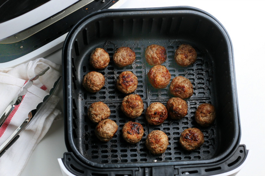 cooked meatballs in an air fryer basket
