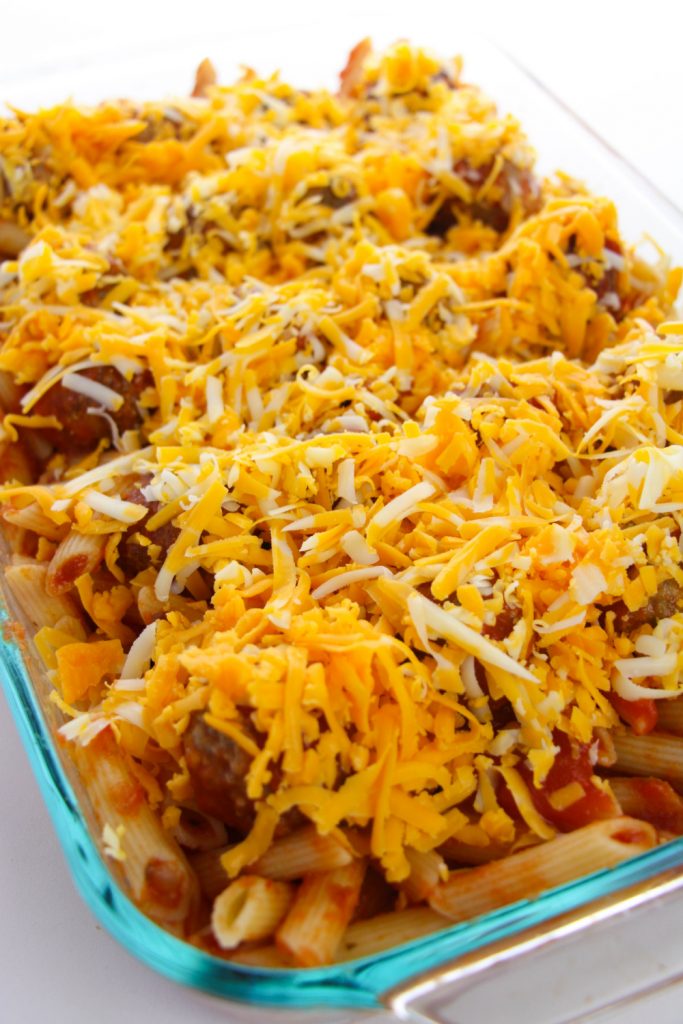 shredded cheese being added to top of casserole