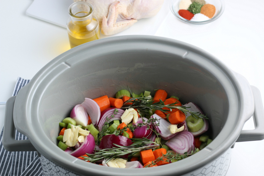 vegetables and herbs in a slow cooker