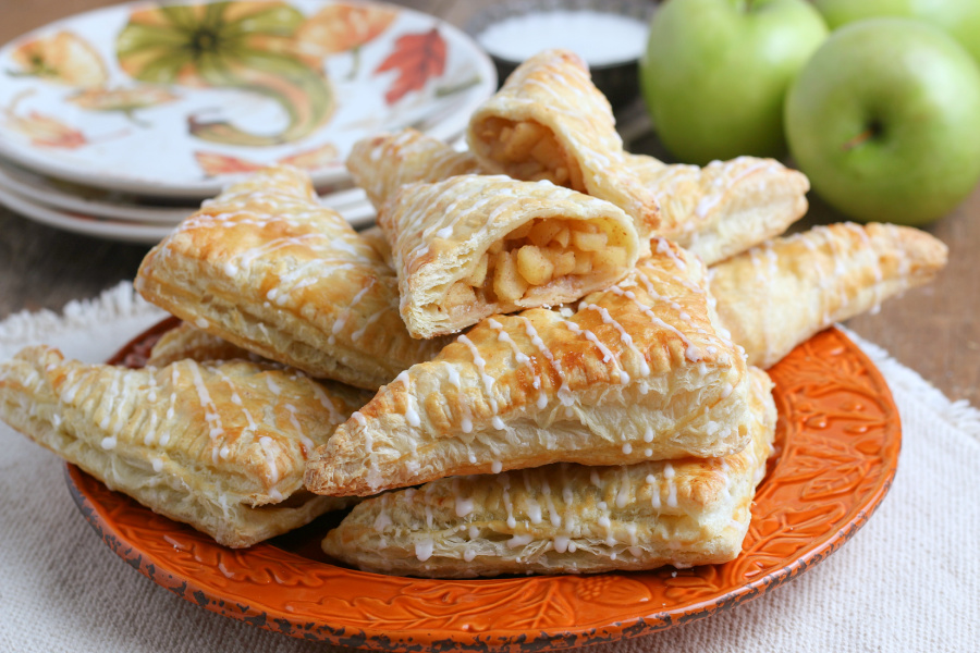 apple turnovers stacked on an orange plate
