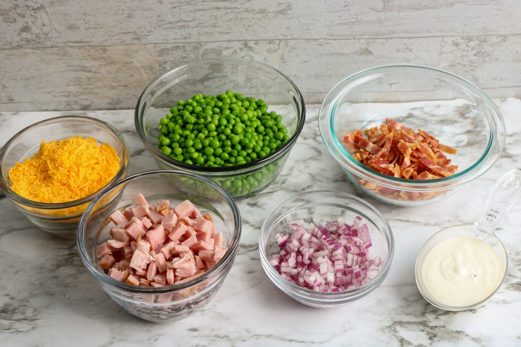 ingredients for classic ham and pea salad in glass bowls