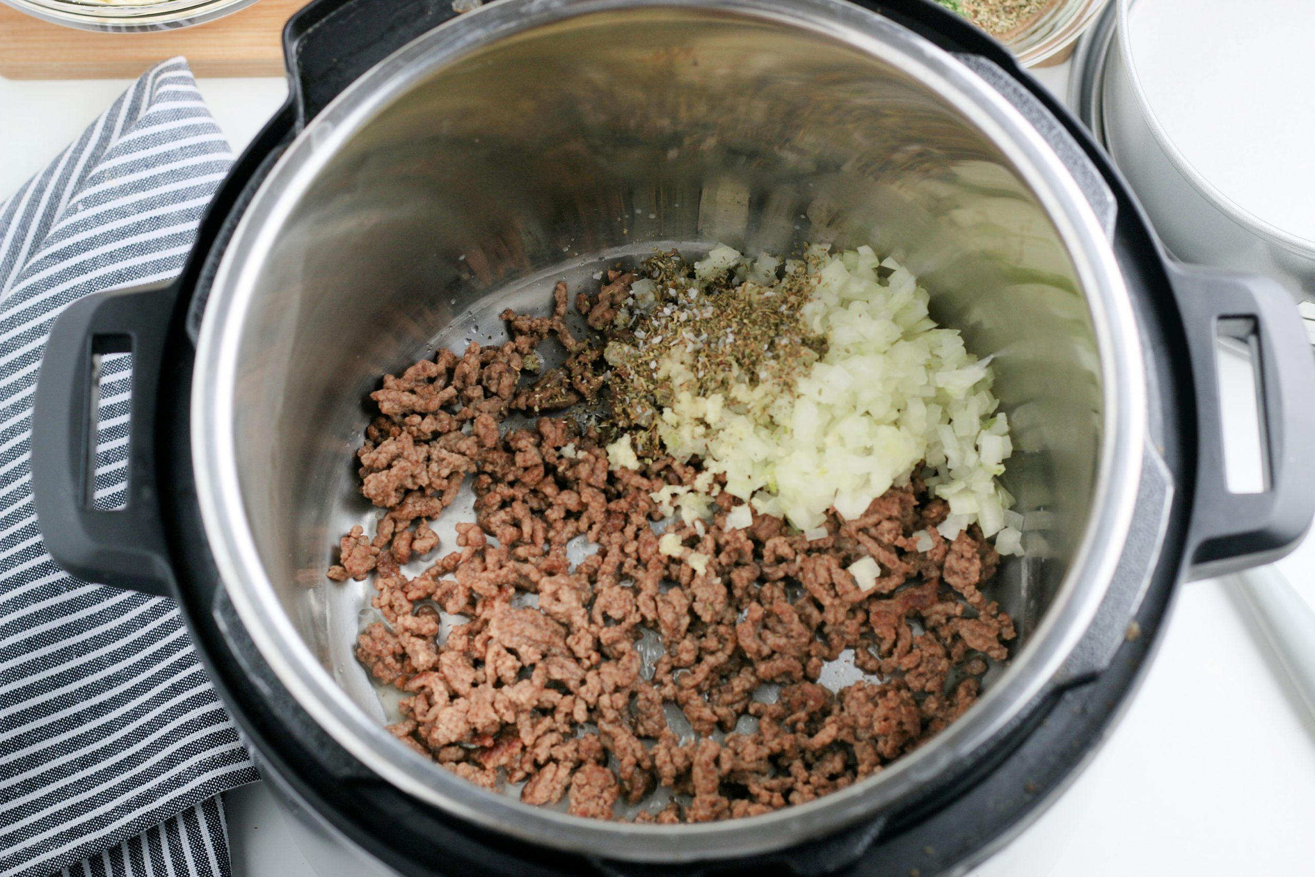 ground beef, seasoning, garlic, and onion cooking in instant pot