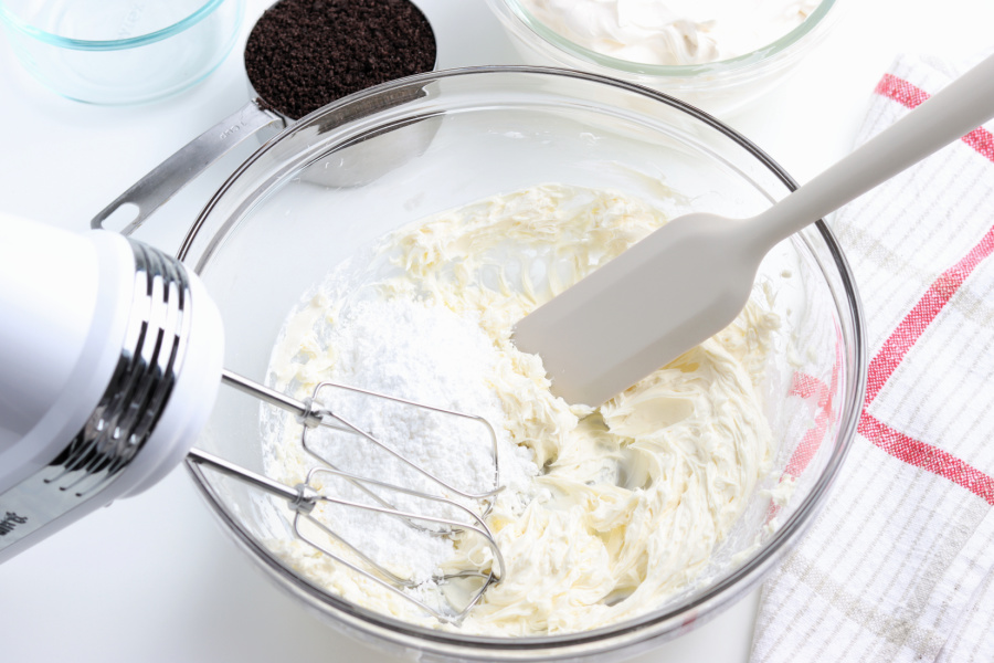 cream cheese and powdered sugar being mixed together 