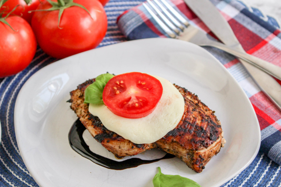 Grilled Caprese Chicken on plate with slice of cheese and tomato