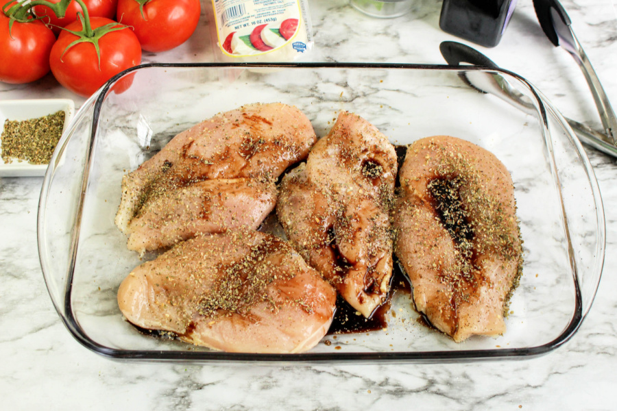 chicken breast in a baking dish with seasoning