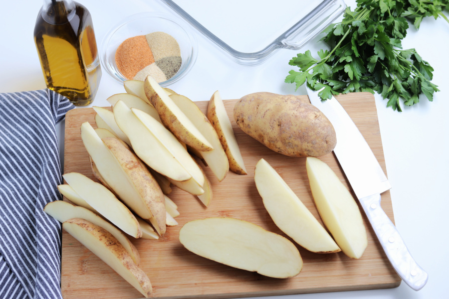 potato sliced in to wedges on cutting board