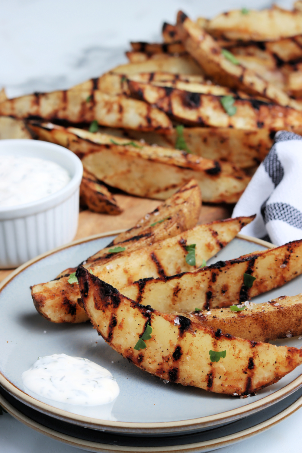 Grilled potato wedges on a plate with dip