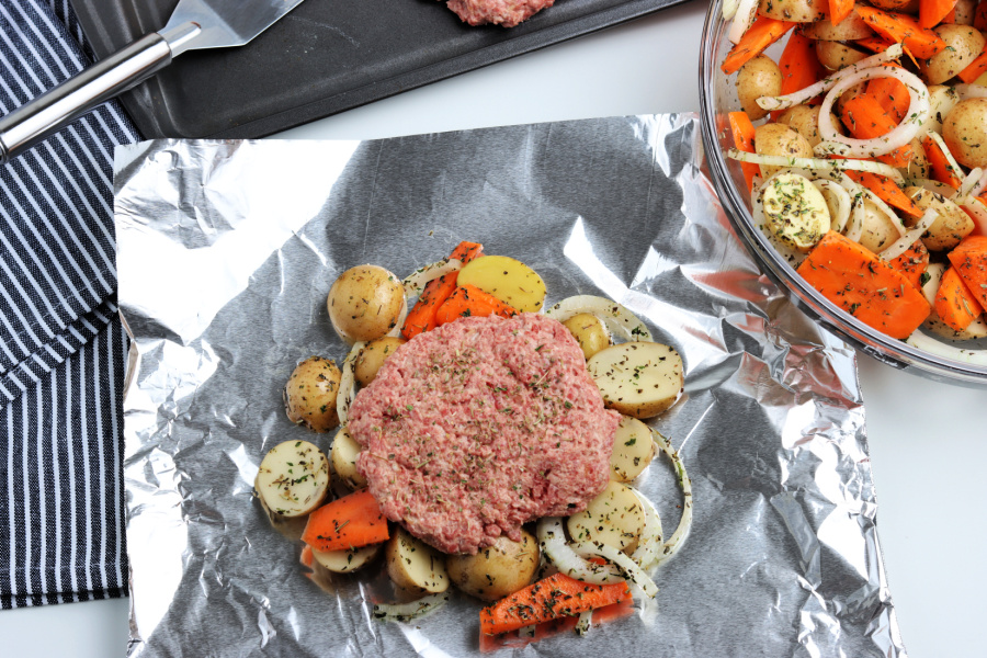 vegetables and beef patty on a piece of foil
