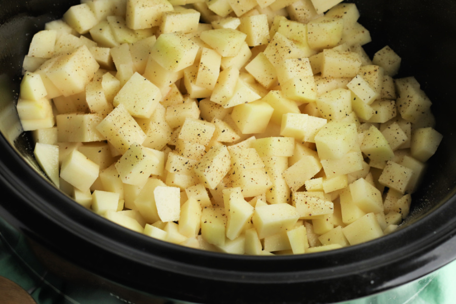 cubed potatoes and seasoning in slow cooker