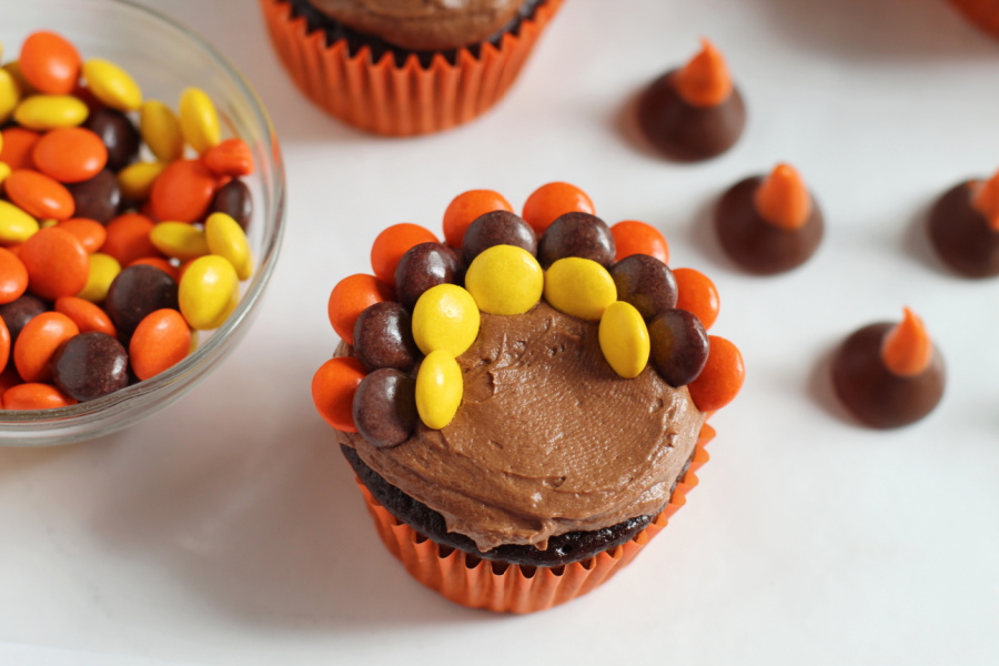 placing rows of Reese's pieces on cupcake