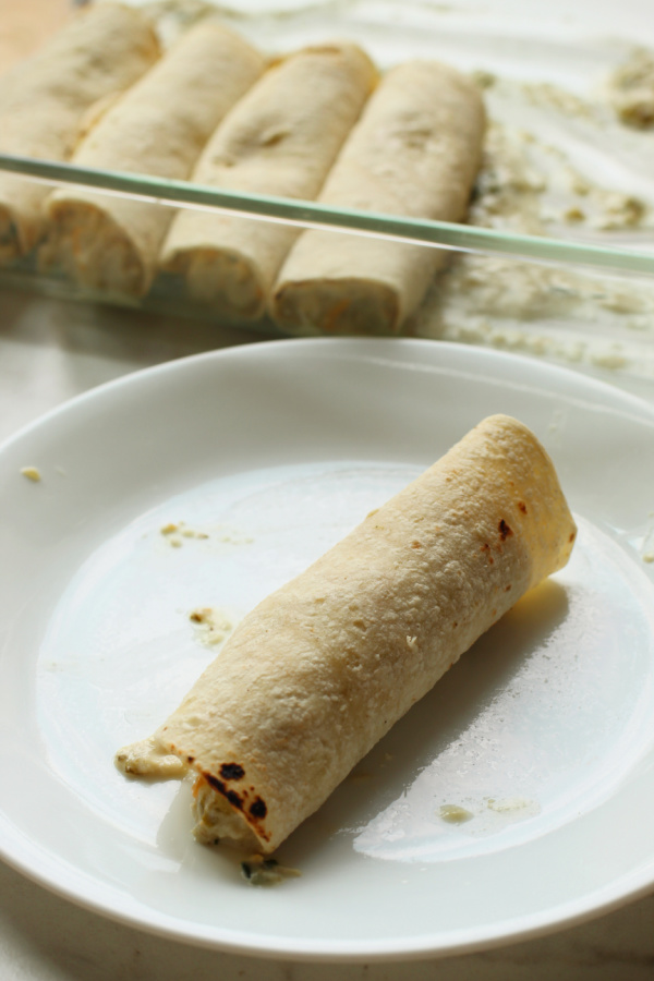 tortillas rolled up on plate and in pan