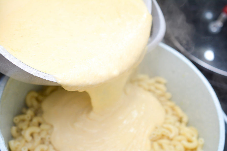 pouring cheese mixture over noodles
