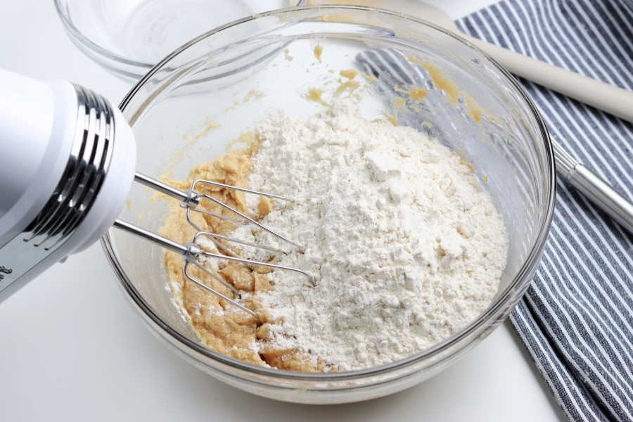 adding dry ingredients into mixing bowl