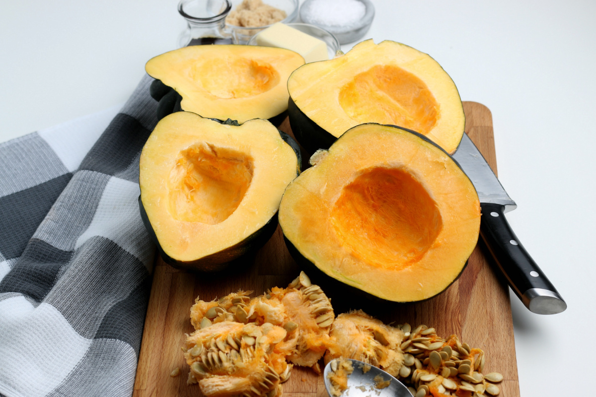 Acorn Squash cut in half on cutting board with seeds removed