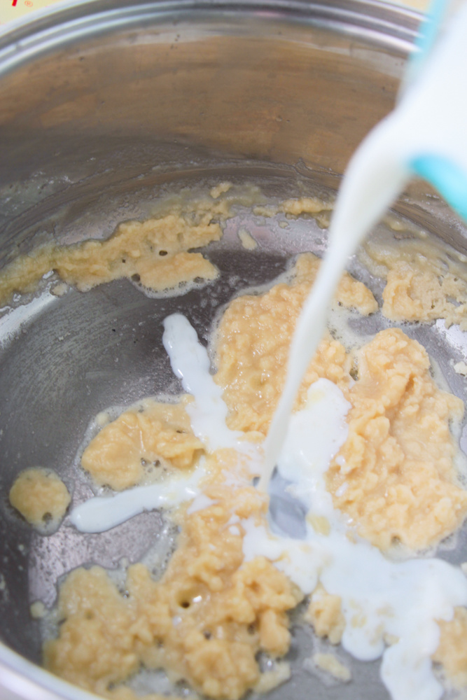 flour and milk and butter being mixed in pan