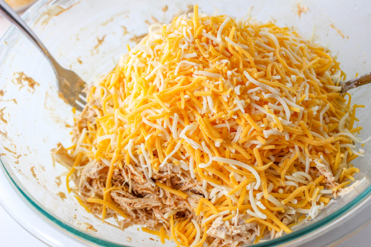 chicken, sour cream, taco seasoning, and 3 cups of cheese in a bowl