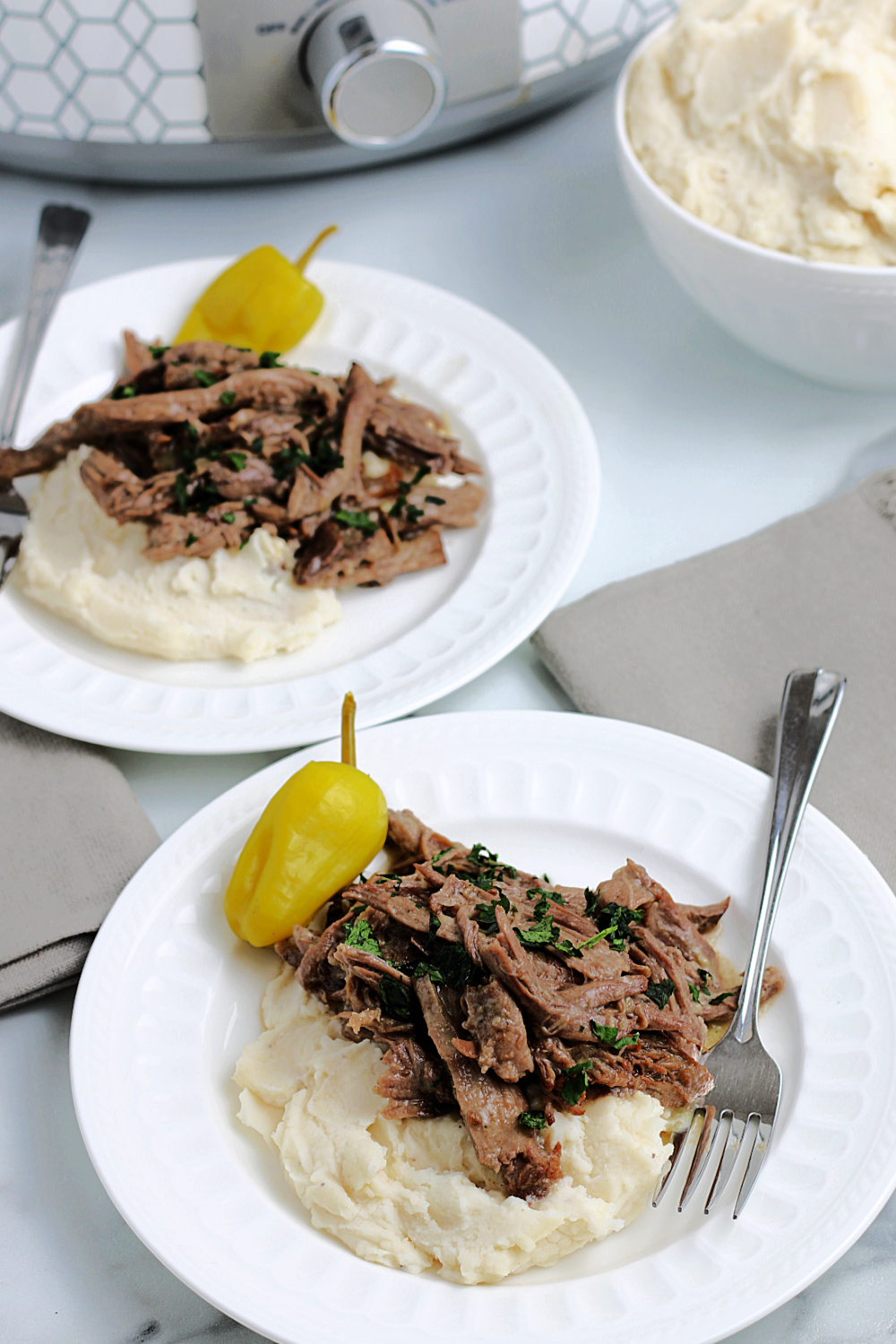 Slow Cooker Mississippi Pot Roast on plates with mashed potatoes 