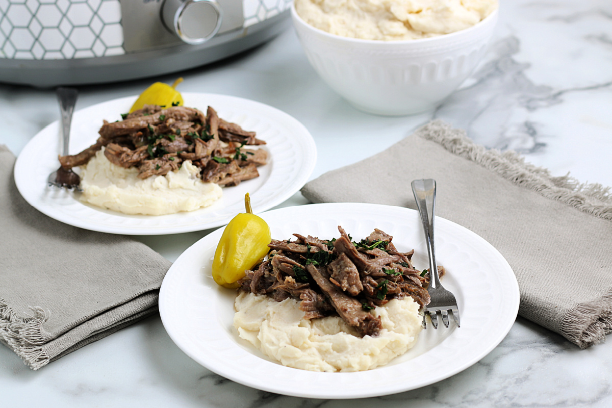 Slow Cooker Mississippi Pot Roast on plates with mashed potatoes
