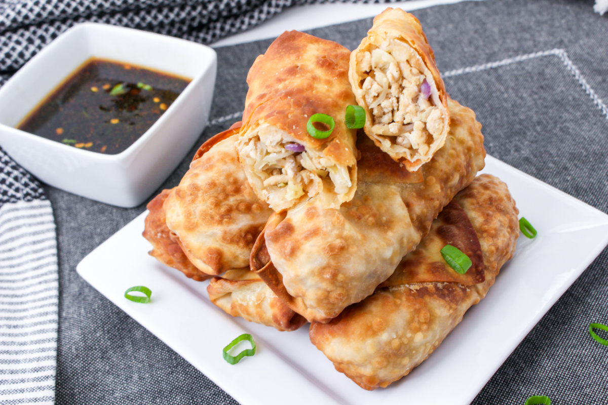 Air Fryer Chicken Egg Rolls on a plate with a side dish of sauce