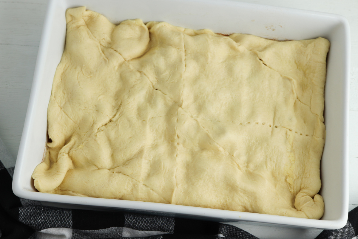 Crescent Roll dough placed on top of peaches
