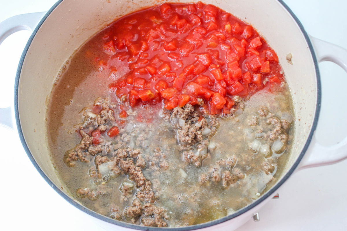 adding  the diced tomatoes and chicken broth to the skillet