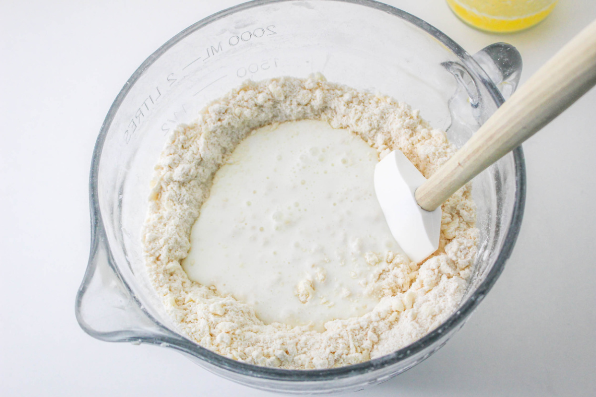 pouring butter milk into bowl with flour mixture