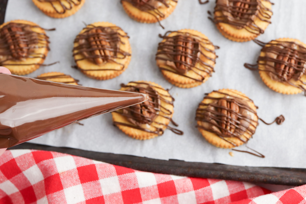 chocolate being drizzled over crackers