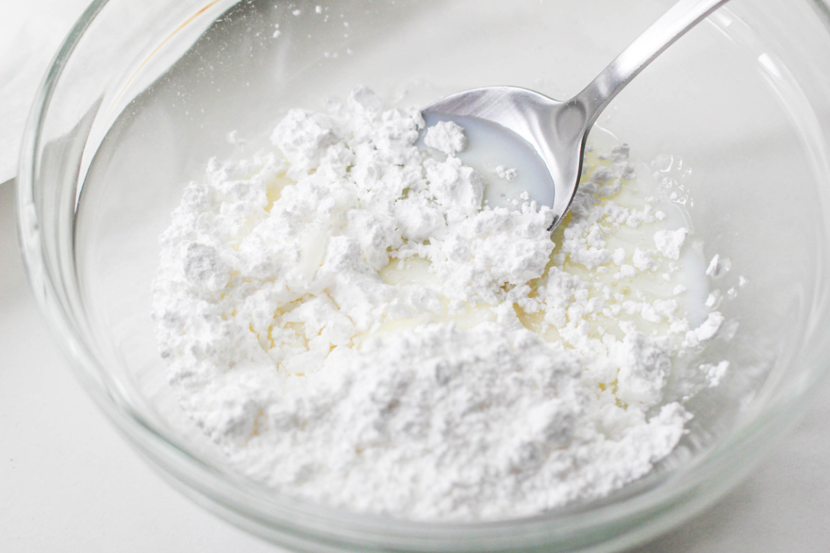mixing powdered sugar and milk in a bowl