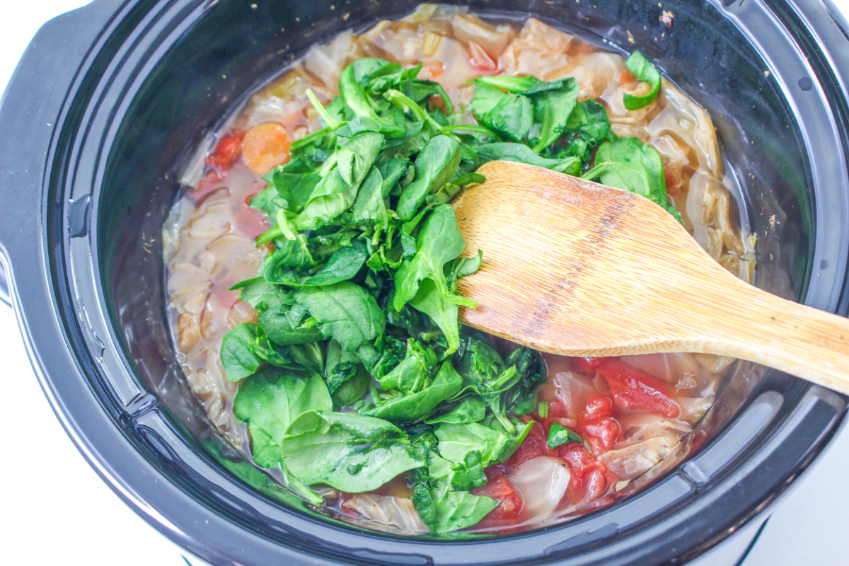 spinach being added to crock pot