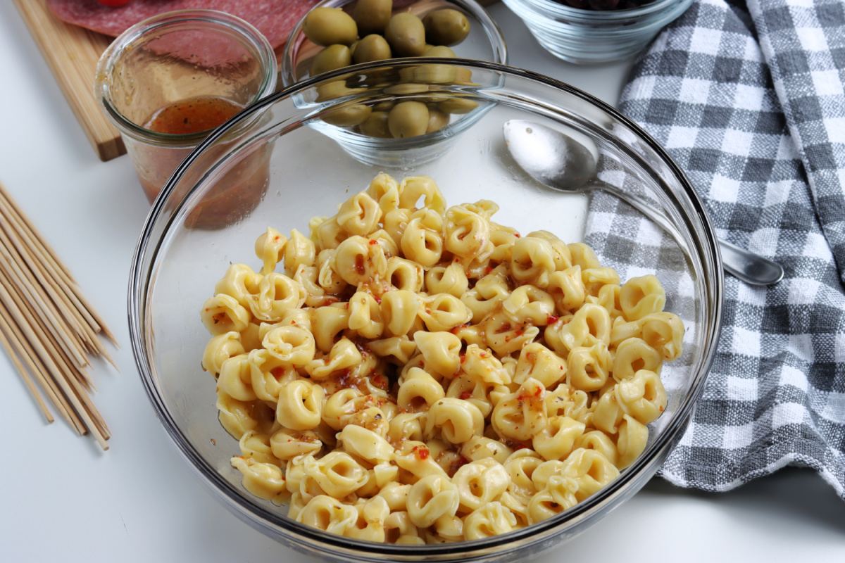 dressing added to bowl with pasta