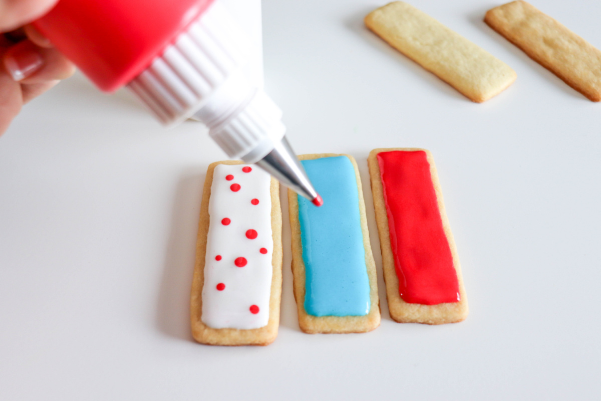 putting frosting dots on sugar cookies