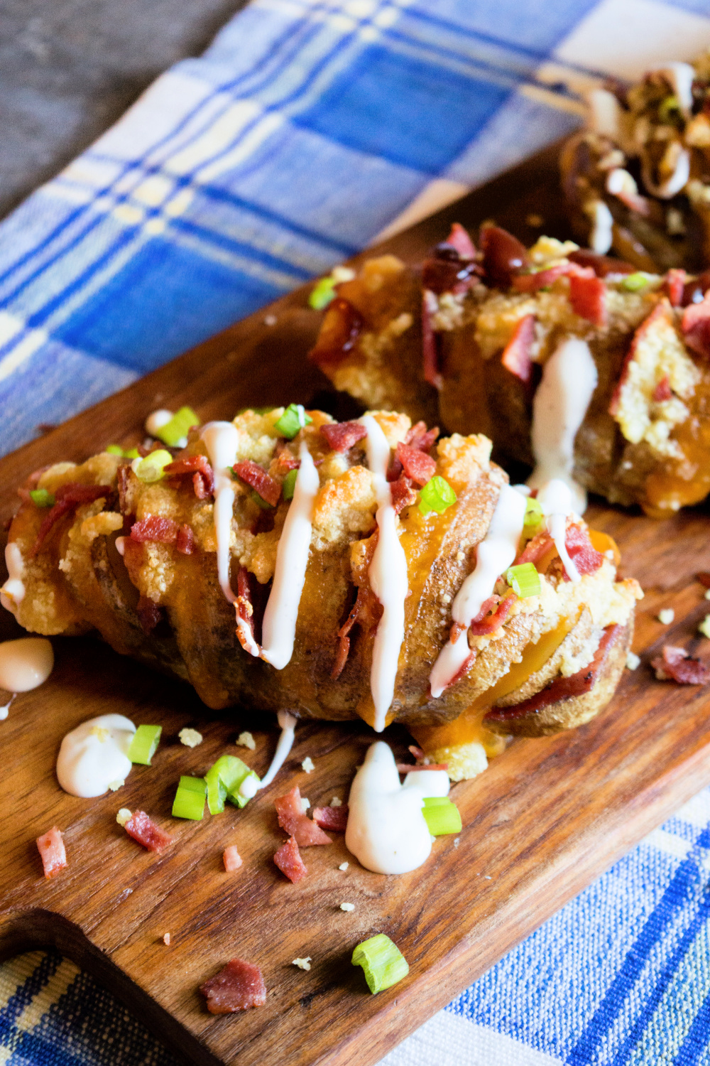 Cheesy Bacon Hasselback Potatoes on a cutting board