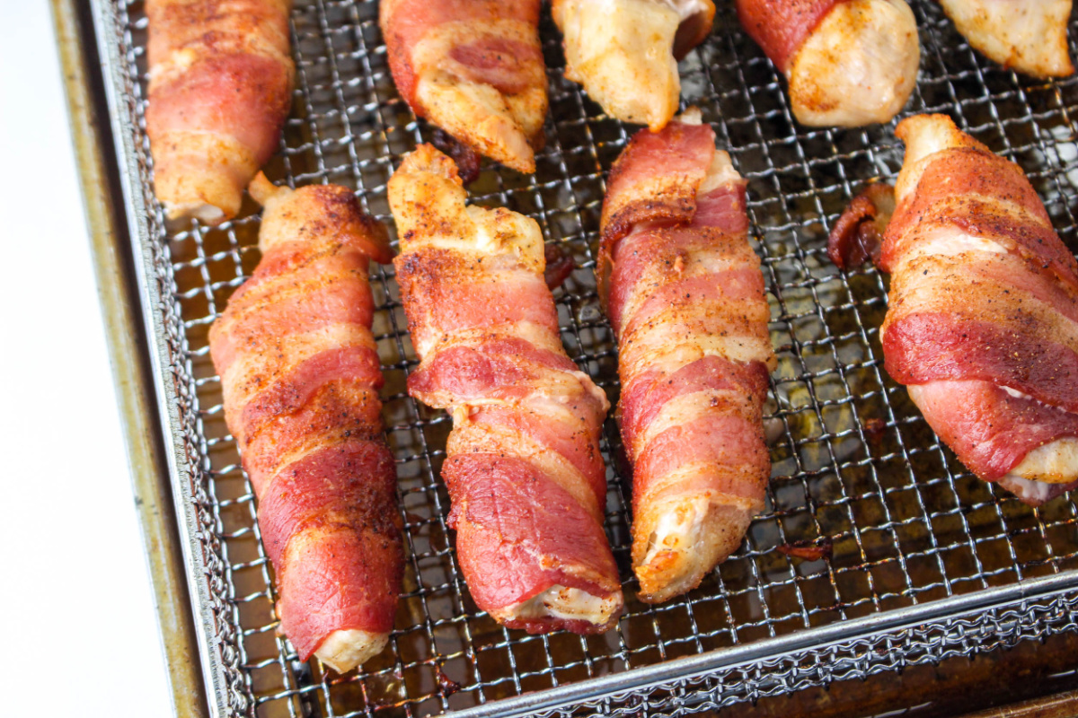 cooked Air Fryer Bacon Wrapped Chicken Tenders on rack