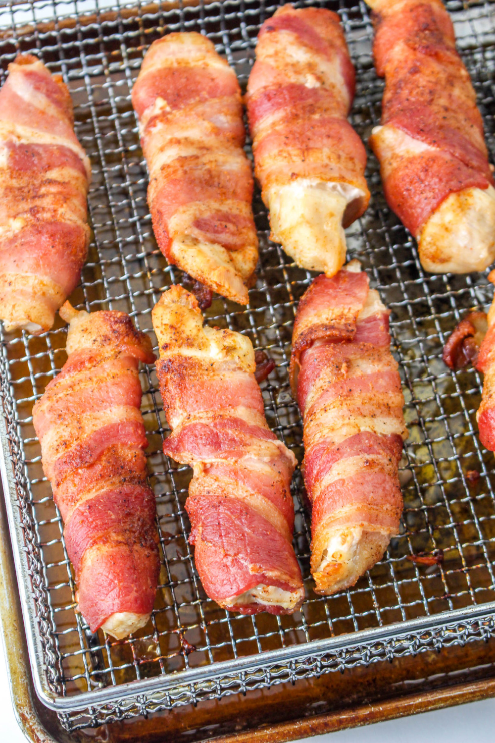 Air Fryer Bacon Wrapped Chicken Tenders on a cooling rack