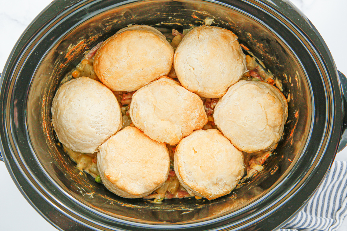 Biscuits added to top of pot pie mixture in a slow cooker