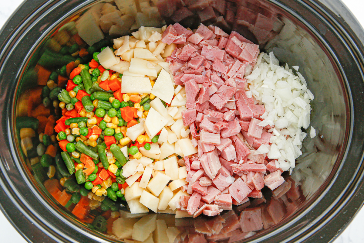 diced ham, potatoes, onions, and vegetables placed in a slow cooker