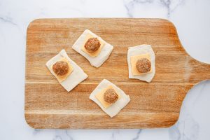 meatball and cheese placed on dough